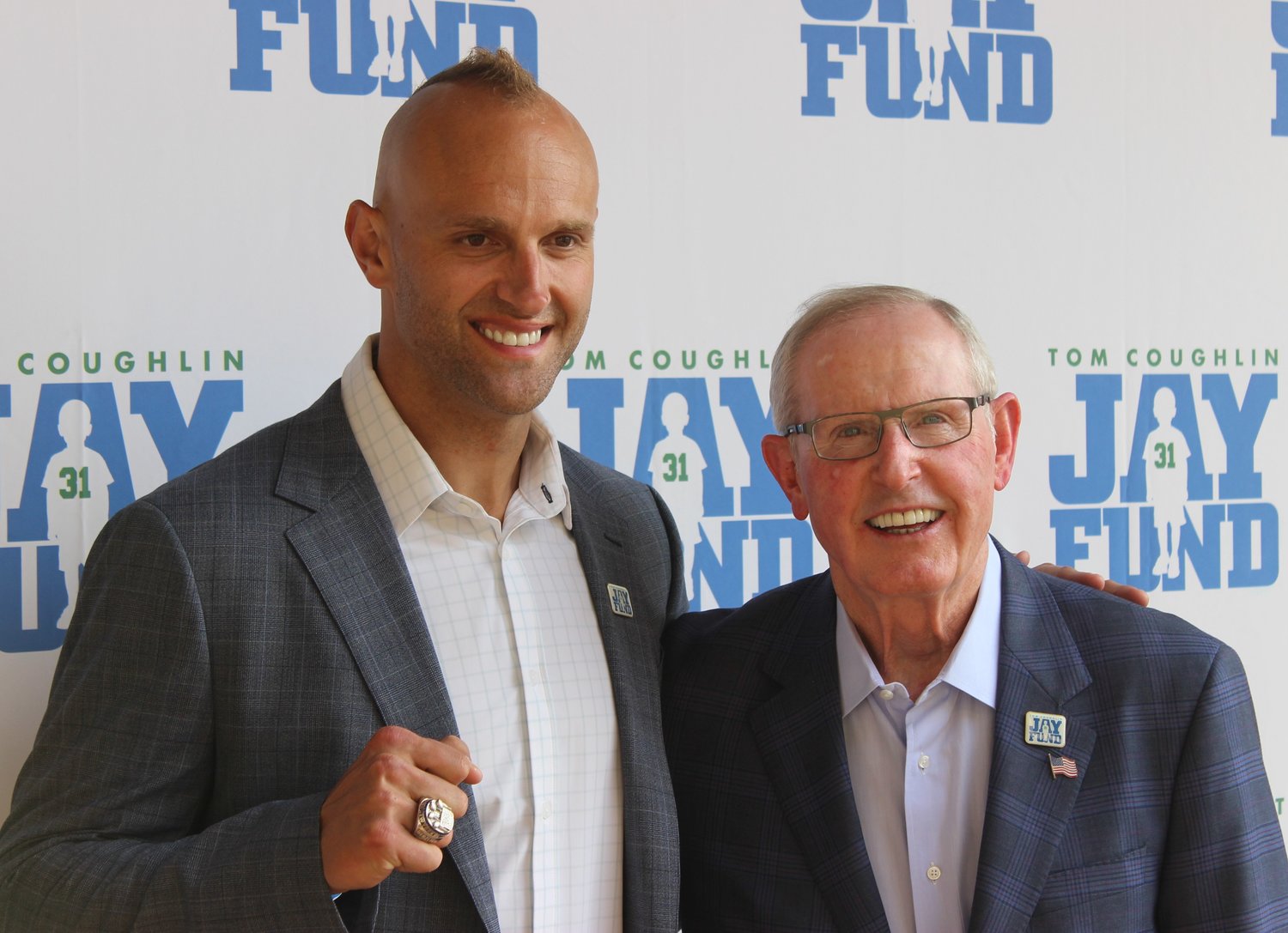 Mark Herzlich shows his Super Bowl ring while standing next to Coach Tom Coughlin.